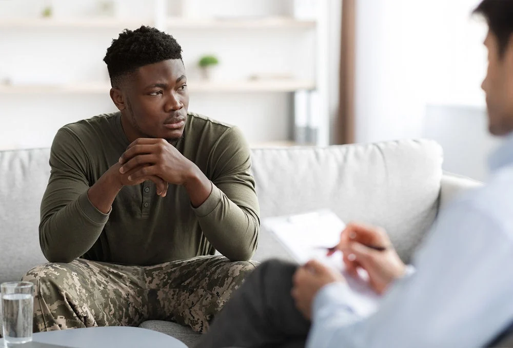 Smiling soldier engaging in conversation with therapist about TriWest insurance benefits