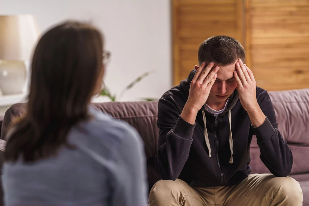 Young man in therapy session, showing the emotional distress of facing addiction to weed and tobacco