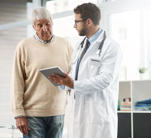 Doctor discussing treatment options with an older man seeking support through addiction rehab.