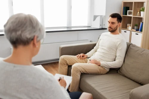 a man sitting on a couch at a rehab center